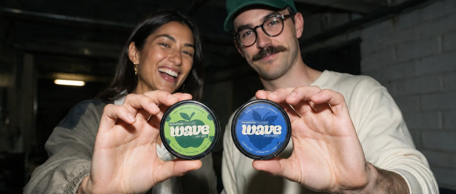 Deux personnes tiennent des boîtes WAVE, Sour Apple et Blue Raspberry.